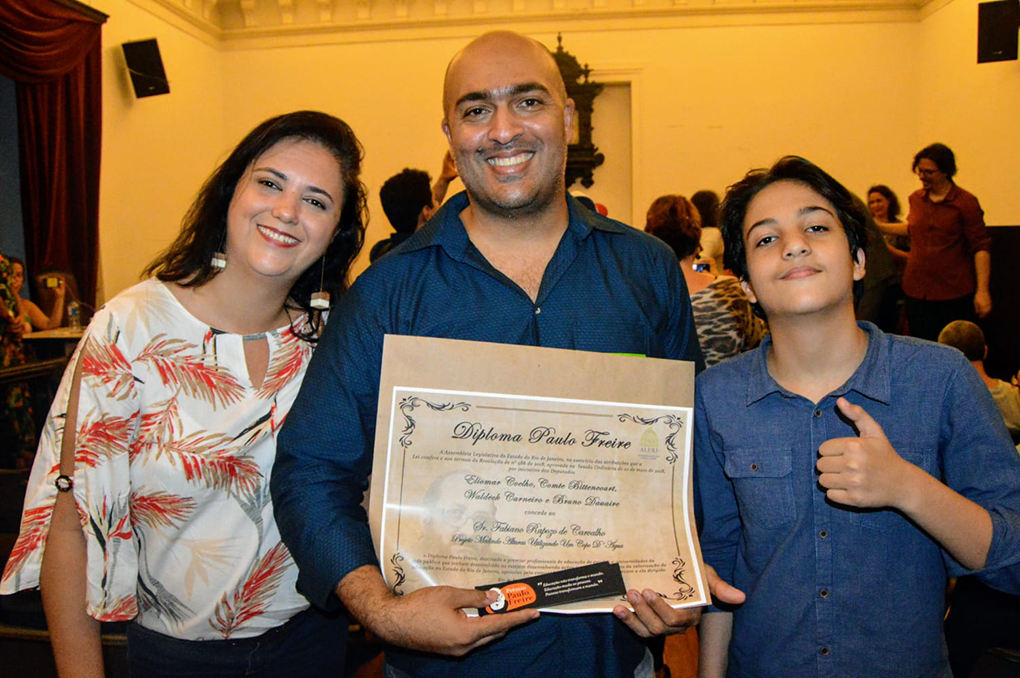 O professor Fabiano com a esposa Francyene e o filho Humberto durante a premiação na UFRJ