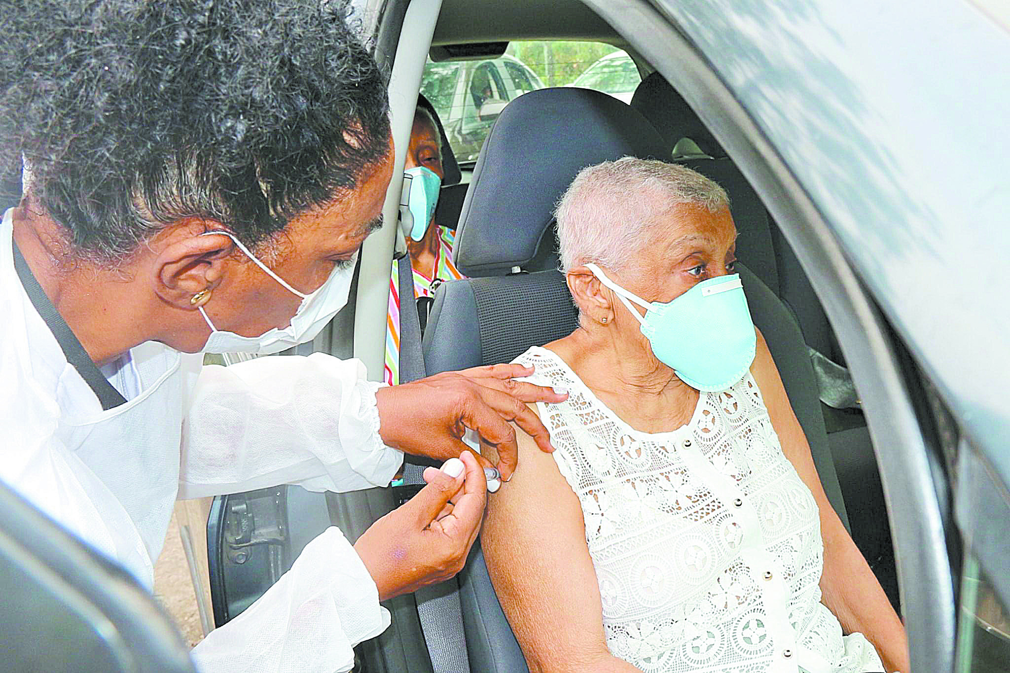 Idosa recebe a primeira dose da vacina dentro do carro