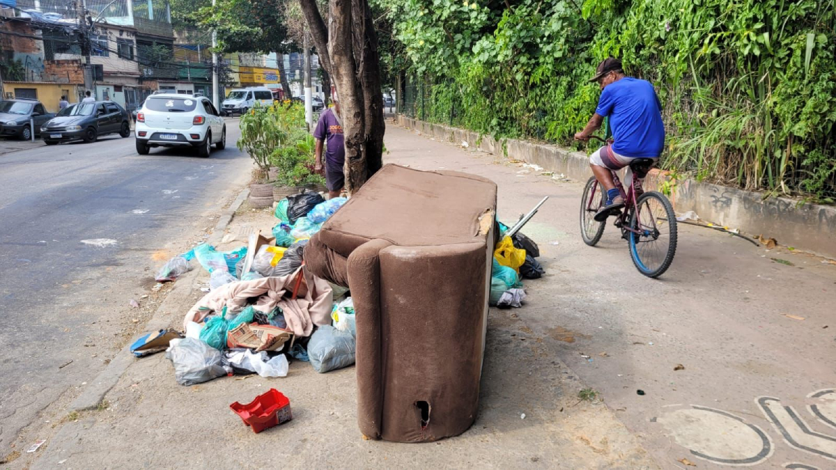 Lixo e sofá velho jogados por moradores na calçada e ciclovia da Estrada do Rio Jequiá