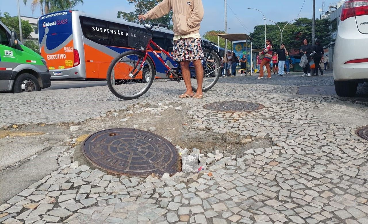 Bueiro levantado e calçada sem manutenção: risco para pedestres na Estrada do Galeão, em frente ao Tubarão Atacadão