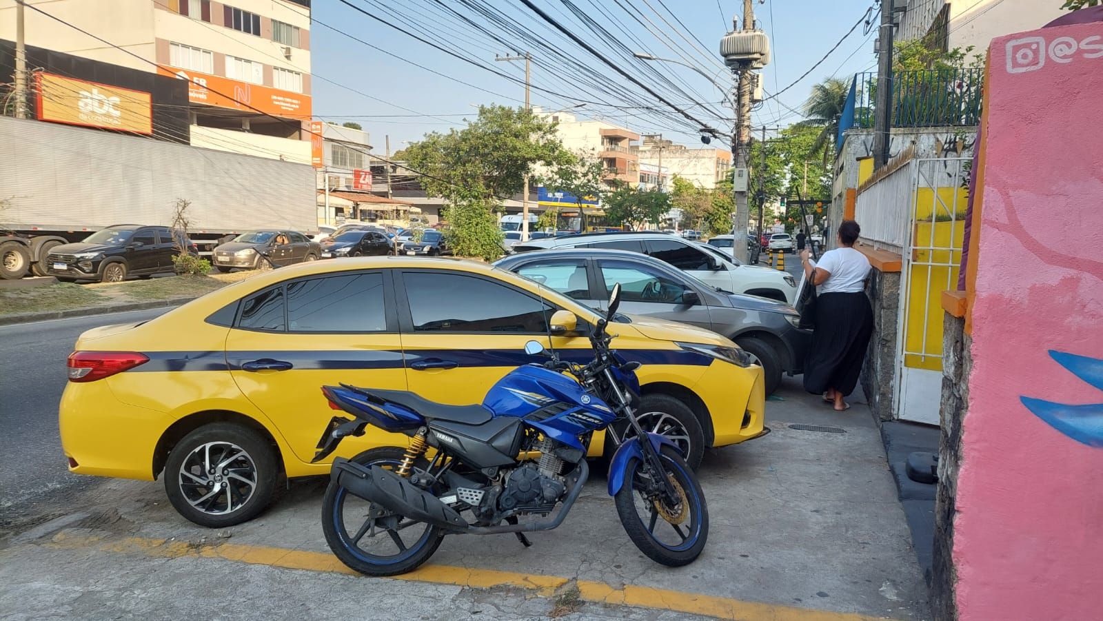 Veículos atrapalham os pedestres na Estrada do Galeão, em frente ao número 1315