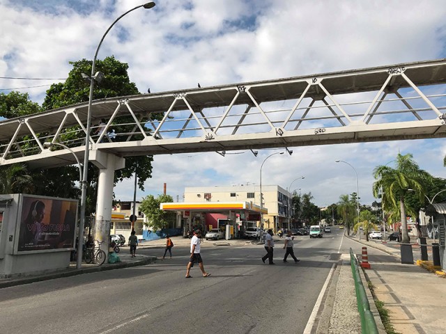 Diariamente pedestres insistem em atravessar a Estrada do Galeão, em frente ao Hipermercado Extra, pela pista, ao invés de usarem a passarela do local