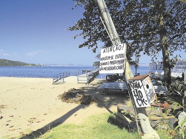 O aviso indignado pendurado no poste inclinado, na  Praia da Bica, tem razão