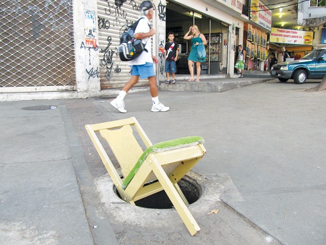 Cadeira quebrada sinaliza bueiro sem tampa na Avenida Paranapuã, no Cocotá