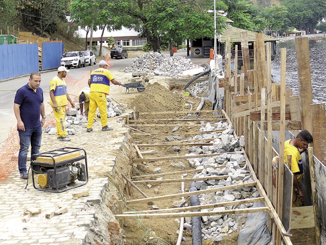 O subprefeito observa as obras da reconstrução da calçada na Praia da Bica