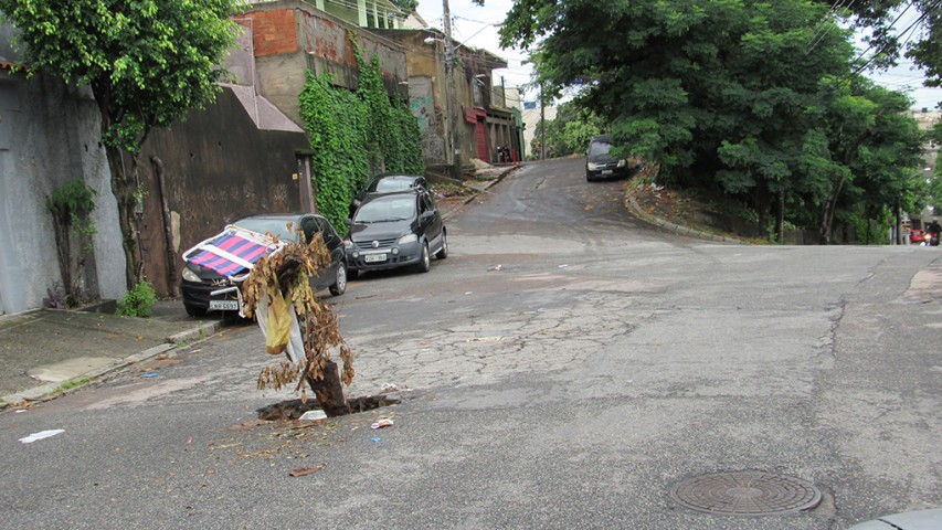 Na Rua Jutlândia, no Jardim Carioca, um buraco que está aberto a semanas precisou ser sinalizado com um galho de árvore, para evitar acidentes no local