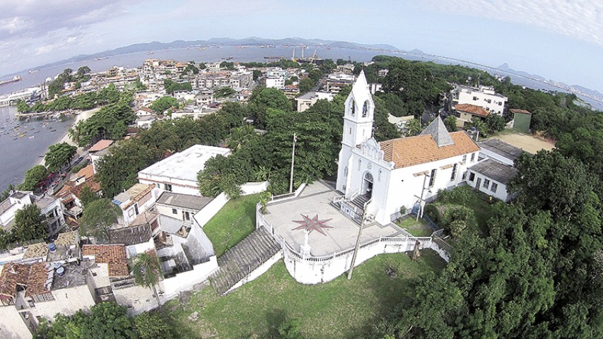 Em primeiro plano está a Igreja do Morro do Ouro fundada em 1913. Ao fundo o bairro da Ribeira e a mata que se estende até a sede da ACM-Ilha