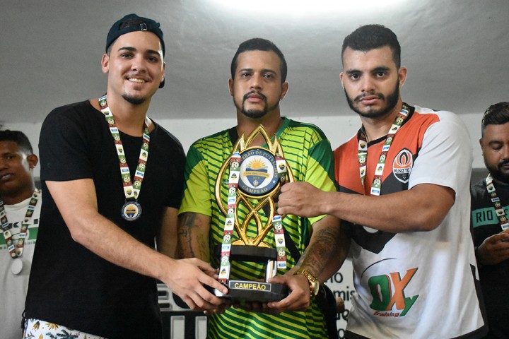 Chakal (centro) entrega o troféu para os representantes da equipe vencedora