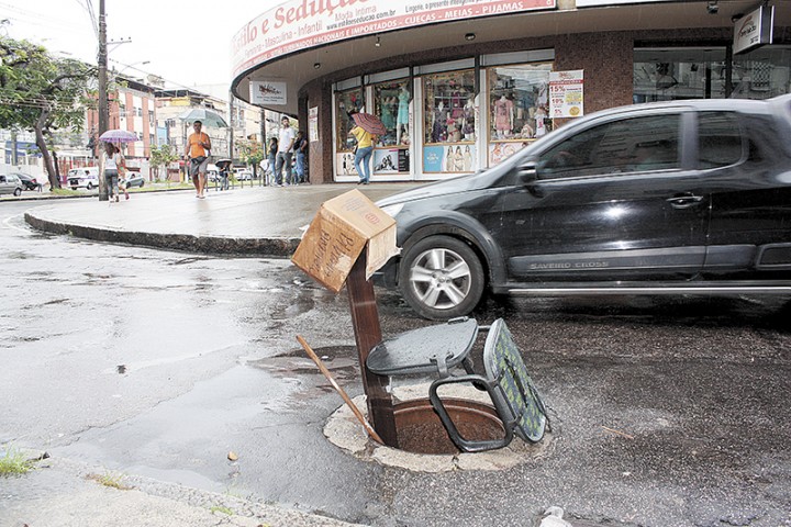 Bueiro sem tampa foi sinalizado com cadeiras na Rua Ericeira, no Cacuia