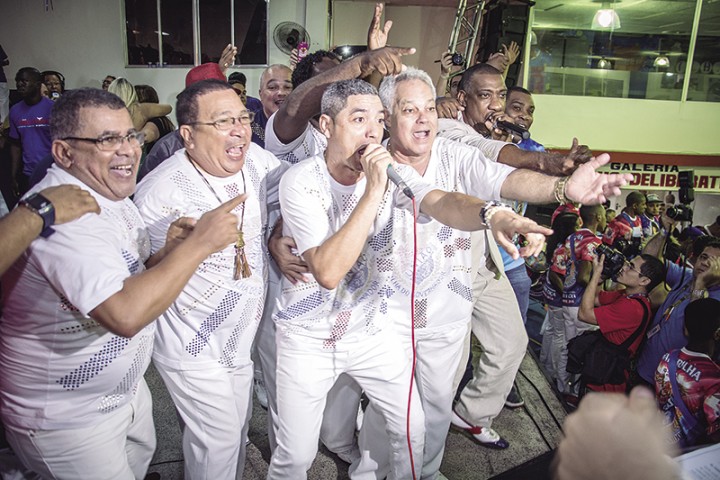 Após o anúncio do samba campeão, Paulo Guimarães vibra entre os cantores Roger Linhares e Ito Melodia