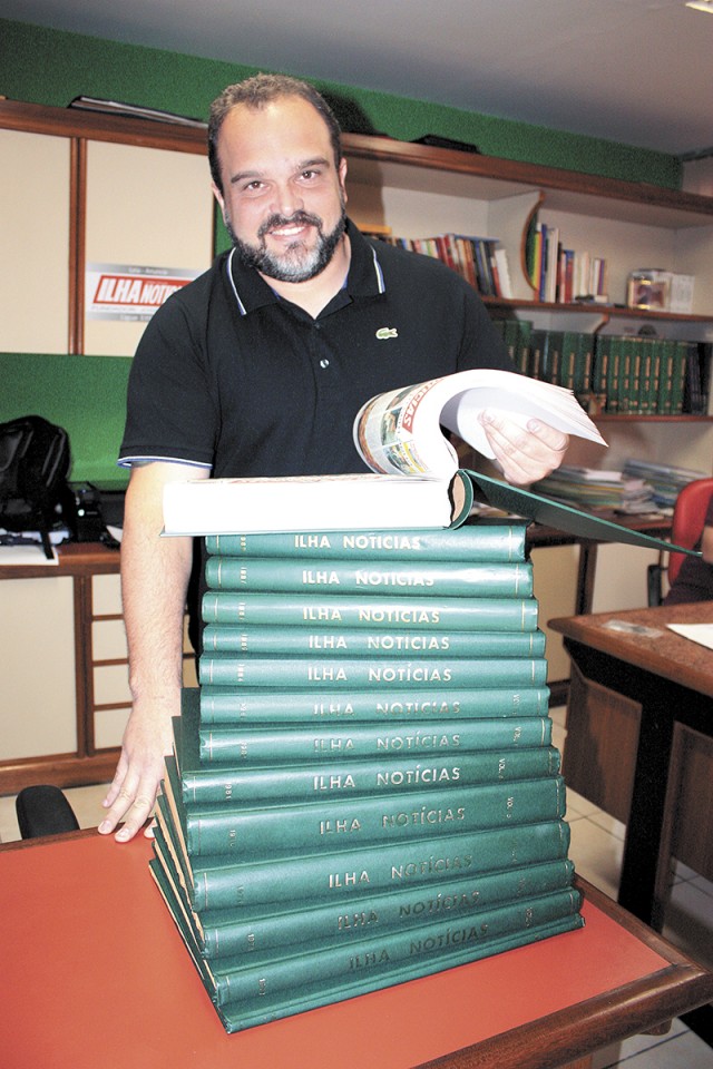 Daniel Balbi, diretor executivo, folheia um dos livros da coleção do jornal Ilha Notícias, que completa 37 anos