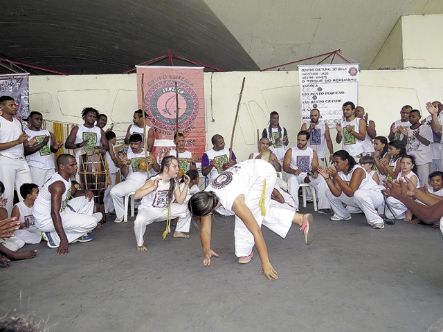 A aluna Rebeca Valadão joga capoeira com os amigos do Grupo Senzala