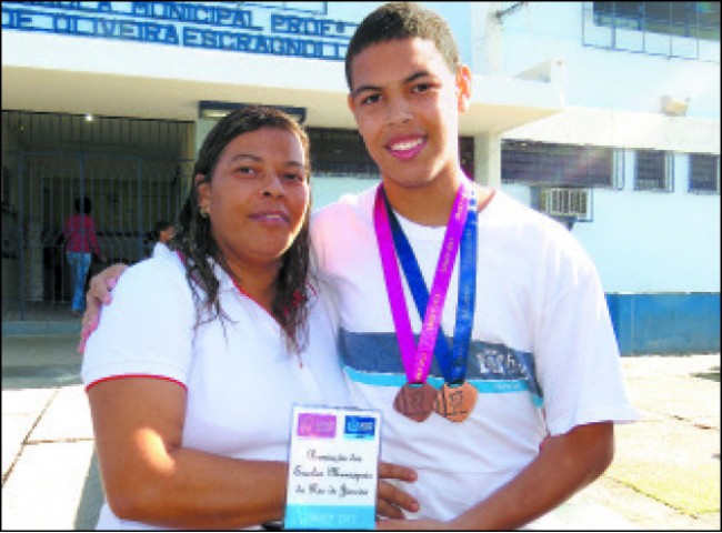 Com a mãe Maria Cristina, Yan mostra as medalhas e o troféu que ganhou na Olimpíadas de Matemática